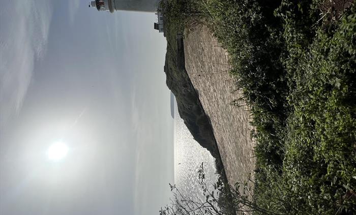 Flat Holm Island Lighthouse with water catchment area on a sunny day.